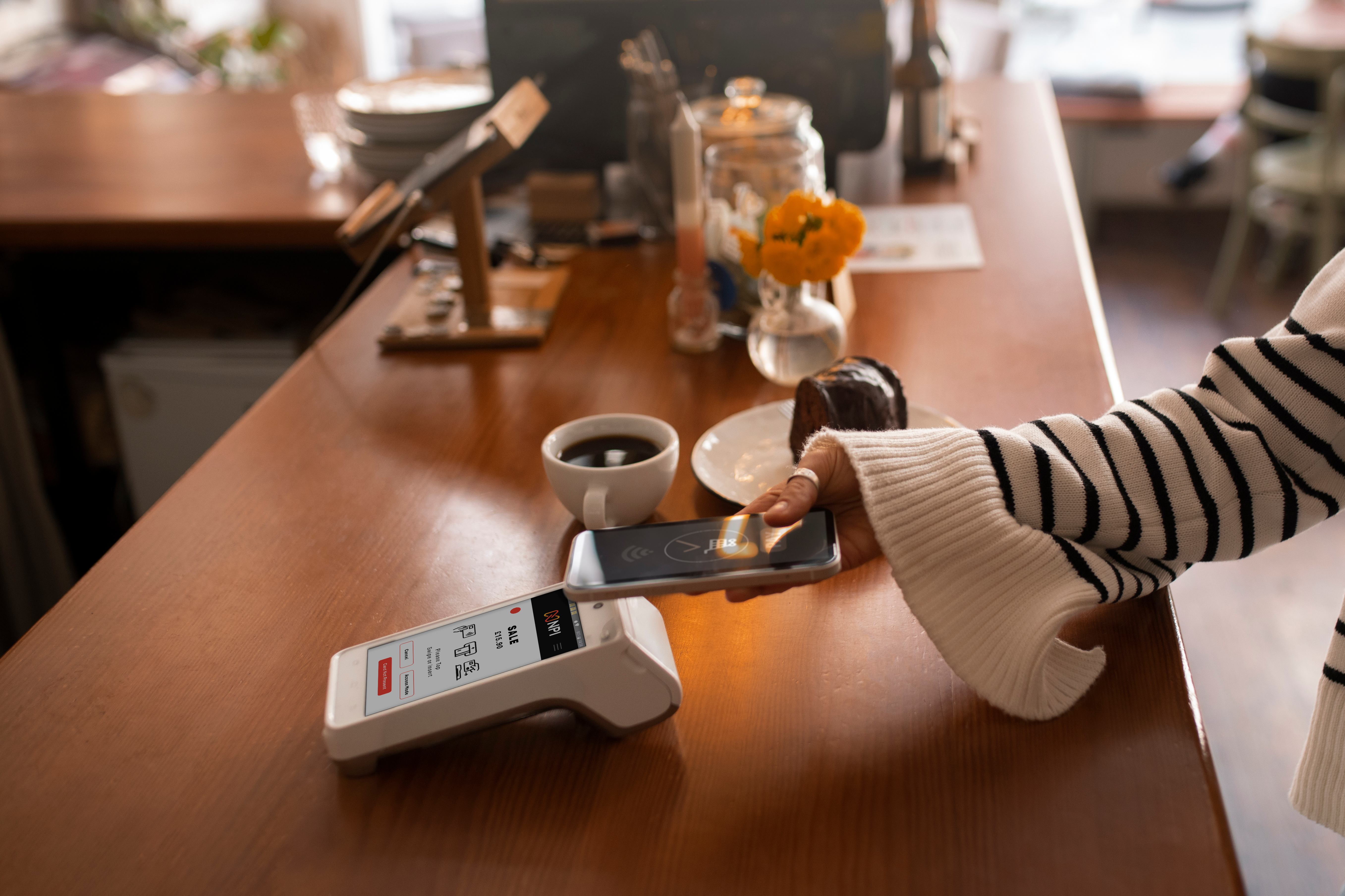 Customer making contactless payment at restaurant counter using PAX A920 PRO terminal for next day settlement UK