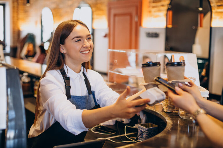 Customer paying for coffee with contactless card using PAX A920 PRO mobile payment terminal at UK coffee shop