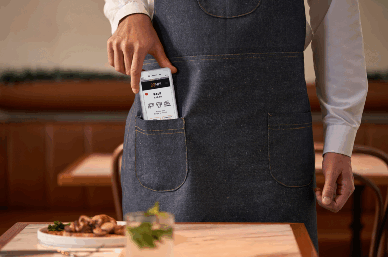 Tradesperson card machines UK PAX A50 portable payment terminal in restaurant apron pocket
