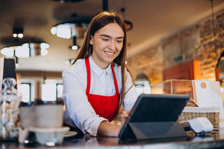 Waiter using EPOS tablet system on coffee counter for hospitality payment processing