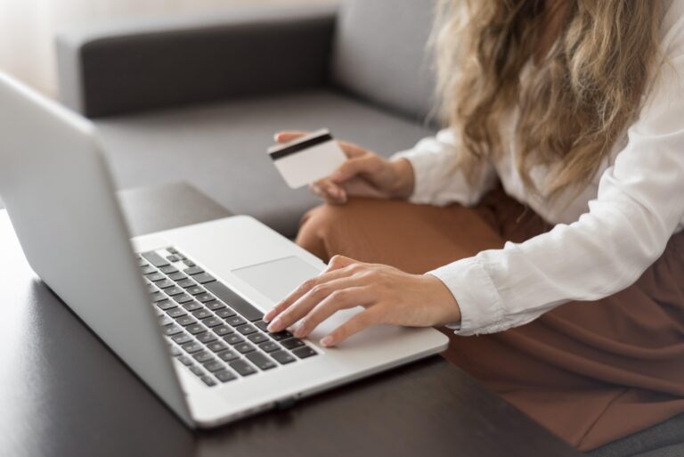 Woman making online payment on laptop checking payment processing fees UK costs