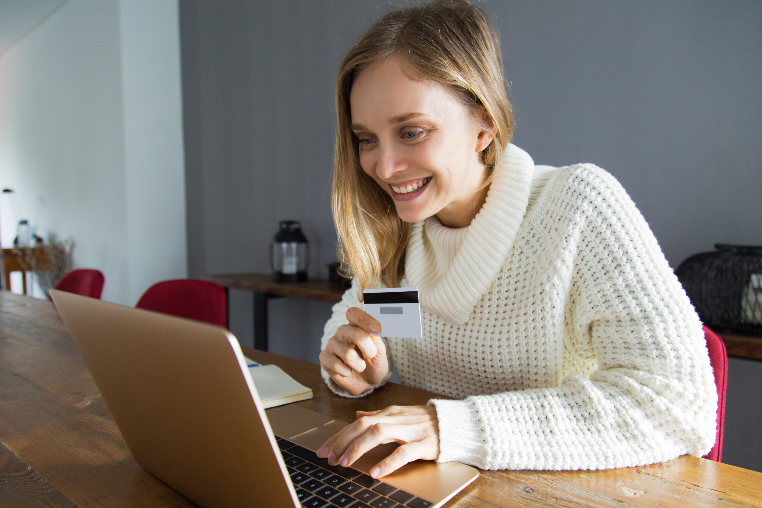 Woman excited about secure online payment gateway UK transaction with card in hand