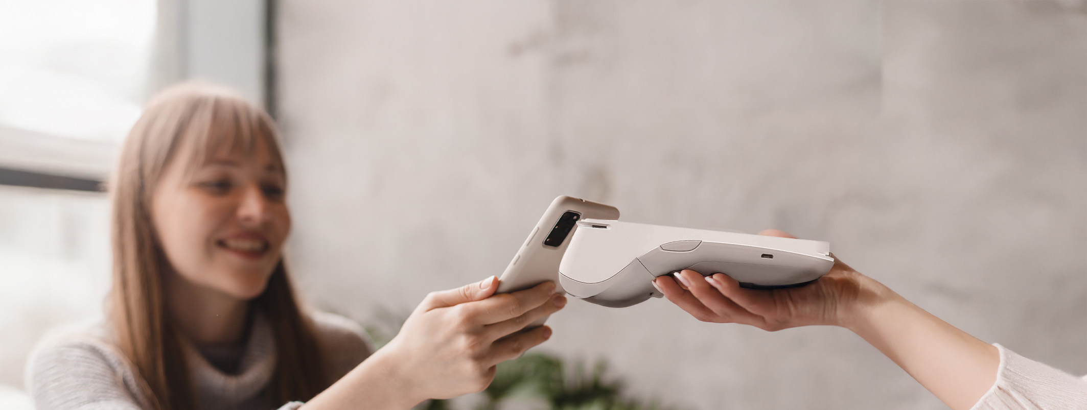 Customer making contactless payment at UK hotel reception using modern hospitality payment solutions