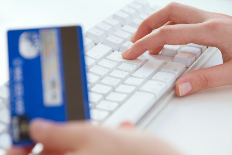 Person making secure online payment on laptop with credit card for UK business transaction
