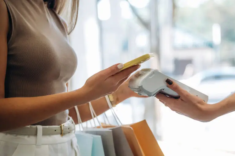 Woman making contactless payment on PAX A920 PRO terminal reflecting UK shopping trends 2026 with shopping bags