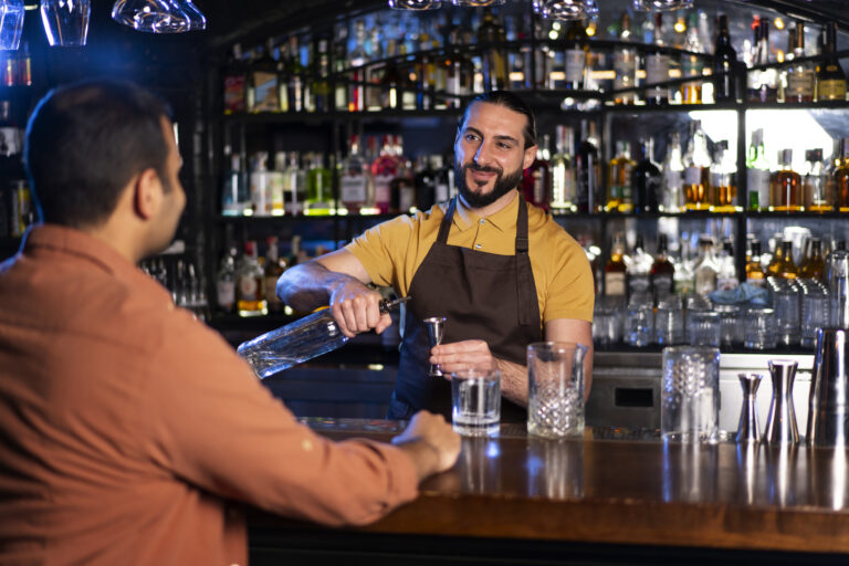 Bartender using a pub card machine UK during a busy night shift