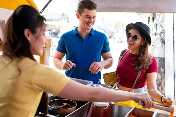 Small food business owner serving a customer at a counter